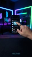 Hand holding smartphone with email icon on screen in neon-lit room with glowing cyan and purple lights, representing digital communication and modern technology for business applications.