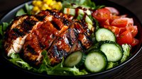 Grilled chicken breast sliced on fresh garden salad with cucumber, cherry tomatoes and mixed greens in dark plate, close up view on wooden table.