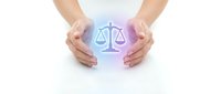Hands protecting glowing justice scales symbol on white background representing legal protection, law firm services, and balanced judgment concepts.