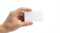 Male hand holding blank white business card mockup on isolated background for corporate branding and contact information design templates.