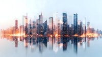 Modern cityscape with glowing orange light reflection in water, skyscrapers silhouettes against pastel sky create mirror effect panorama. Urban architecture photography.
