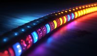 Colorful illuminated LED light strip with vibrant blue, pink, yellow and orange glowing elements creating dynamic lighting effect on dark surface.