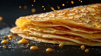 Stack of golden thin crepes or pancakes with honey dripping, close-up food photography on dark background with warm bokeh lights for culinary content.