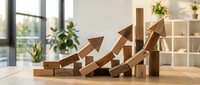 Wooden arrow blocks arranged in ascending growth pattern on desk representing business success, financial progress and upward trending performance metrics.