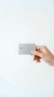 Hand holding blank silver credit card with chip on white background for financial services and banking mockup design.
