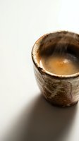 Rustic ceramic cup filled with aromatic espresso coffee, isolated on white background. Perfect for beverage, café, and hospitality design projects.