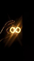 Hand holding glowing infinity symbol with golden light rays on dark background, representing endless possibilities, innovation, and limitless potential for business concepts.