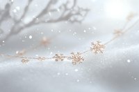 Delicate rose gold snowflakes floating on soft white background with gentle bokeh effect and falling snow creates dreamy winter atmosphere.