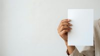 Young adult with medium brown skin tone holding blank white paper against neutral background, suitable for advertising, marketing campaigns, and promotional materials.