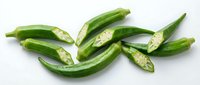 Fresh green serrano peppers whole and sliced showing seeds on white background isolated for cooking ingredients and spicy food preparation.