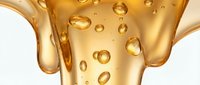 Golden oil or serum pouring with bubbles, isolated on white background. Suitable for cosmetics, skincare, wellness, and beauty product packaging design.