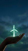 Hand holding glowing wind turbine with magical sparkles against blue sky background representing renewable energy and environmental protection.
