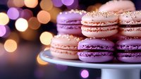 Sweet pastel macarons in pink and purple shades on white plate with soft bokeh lights background creating romantic festive atmosphere.