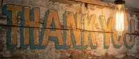 Vintage neon sign with thank you text on weathered brick wall, industrial decor for restaurants, cafes, retail stores, hospitality venues.