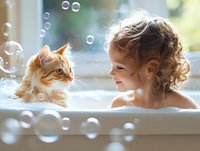 Young girl with curly blonde hair bathing in a tub with an orange tabby cat, surrounded by floating soap bubbles near a bright window. Playful moment capturing childhood joy and pet companionship.