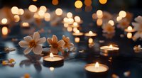 Glowing tea light candles and white magnolia flowers create serene atmosphere on dark surface with magical bokeh lights in background. Perfect for spa or meditation.