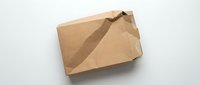 Damaged brown cardboard shipping box with torn corner on white background. Delivery mishap concept for e-commerce and postal service issues.