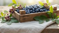 Fresh blueberries in rustic wooden crate with green leaves on linen cloth. Organic summer berries harvest for healthy eating and cooking recipes.