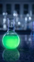 Glass flask with bright green chemical solution in modern laboratory setting with bokeh lights and reflective surface for scientific research.