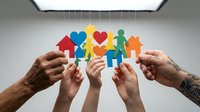Diverse hands holding colorful paper cutout family figures with hearts and house symbols, representing community support, togetherness, and charitable giving for nonprofit campaigns.