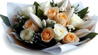 Elegant mixed rose bouquet with peach and white roses, baby's breath and eucalyptus leaves wrapped in brown paper for romantic occasions and celebrations.