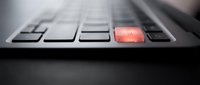 Close-up of laptop keyboard with glowing red Enter key highlighting technology and computing concepts for business and office work applications.