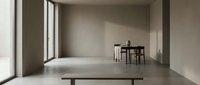 Minimalist interior space with concrete floors, neutral walls, and natural light from large windows, featuring modern furniture for contemporary design projects.