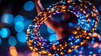 Glowing spiral light trail with blue and orange bokeh effect creates magical atmosphere. Festive illumination for holiday designs and celebrations.