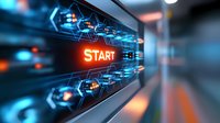 Glowing orange start button on futuristic technological interface with blue hexagonal pattern and depth of field effect creating dynamic perspective.