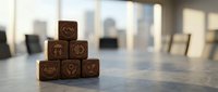Wooden blocks stacked in pyramid formation with zodiac symbols, arranged on office desk with blurred cityscape background for astrology and business concepts.