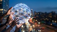 Diverse hands holding a glowing digital globe over a city at night, symbolizing global connectivity and teamwork.
