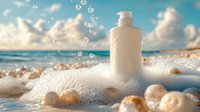 White cosmetic bottle in soap foam and bubbles on sandy beach with turquoise ocean and cloudy sky background, natural skincare product photography.