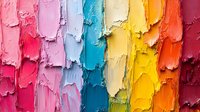 Vibrant rainbow colored oil paint texture with thick impasto brush strokes creating vertical lines in pink, blue, yellow and orange hues. Abstract artistic background.