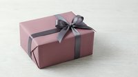Elegant pink gift box with gray satin ribbon bow on white background, isolated for holiday celebrations, birthdays, and special occasions design use.