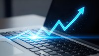 Digital growth arrow emerging from laptop screen with glowing blue light effects representing business success and financial progress in technology sector.