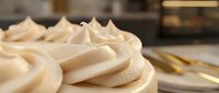 Creamy vanilla meringue frosting piped in decorative swirls, ready for cake decorating, baking projects, and culinary design applications.