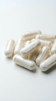 White dietary supplement capsules arranged on neutral background for healthcare and wellness applications.