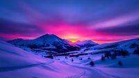 Dramatic winter sunset over snow-covered mountain landscape with vibrant purple and pink sky illuminating pristine white slopes and scattered evergreen trees in valley.