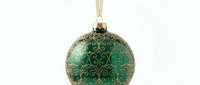 Elegant green Christmas ornament with golden decorative patterns and ribbon on white background isolated for holiday design projects.