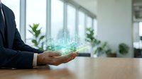 Businessman holding glowing holographic cityscape in hands at wooden desk with windows and plants, representing smart city technology, urban development, and digital innovation for business solutions.