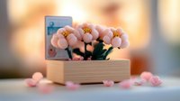 Miniature pink flowers in wooden box with soft bokeh background creating romantic atmosphere for home decor and gift concepts.