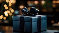 Elegant navy blue gift box with black satin ribbon bow against blurred golden bokeh lights creating festive holiday atmosphere. Perfect for celebration designs.