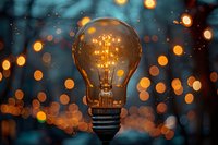 Glowing vintage light bulb with warm filament against blurred bokeh lights background creating magical evening atmosphere for creative concepts.