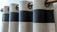 Modern two-tone curtains with metal grommets featuring clean horizontal stripes in beige and charcoal gray colors, creating contemporary window treatment design.