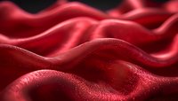 Luxurious red silk fabric with flowing waves and soft folds creating elegant texture for fashion and textile design projects.