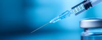 Medical syringe with needle and vial on blue background, close-up view showing transparent liquid medication ready for injection in healthcare setting.