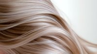 Smooth flowing blonde hair strands with gentle waves creating elegant texture and movement against white background, highlighting natural shine and healthy appearance.