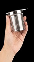 Hand holding a stainless steel mesh tea infuser strainer, isolated on transparent background, ready for clipart, print on demand, stickers, and t-shirt design use.
