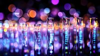 Glass test tubes with glowing blue liquid against dark background with purple and orange bokeh lights creating magical laboratory atmosphere.