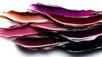 Colorful makeup smears and cosmetic texture samples in purple, pink and burgundy shades isolated on white background for beauty and fashion design projects.